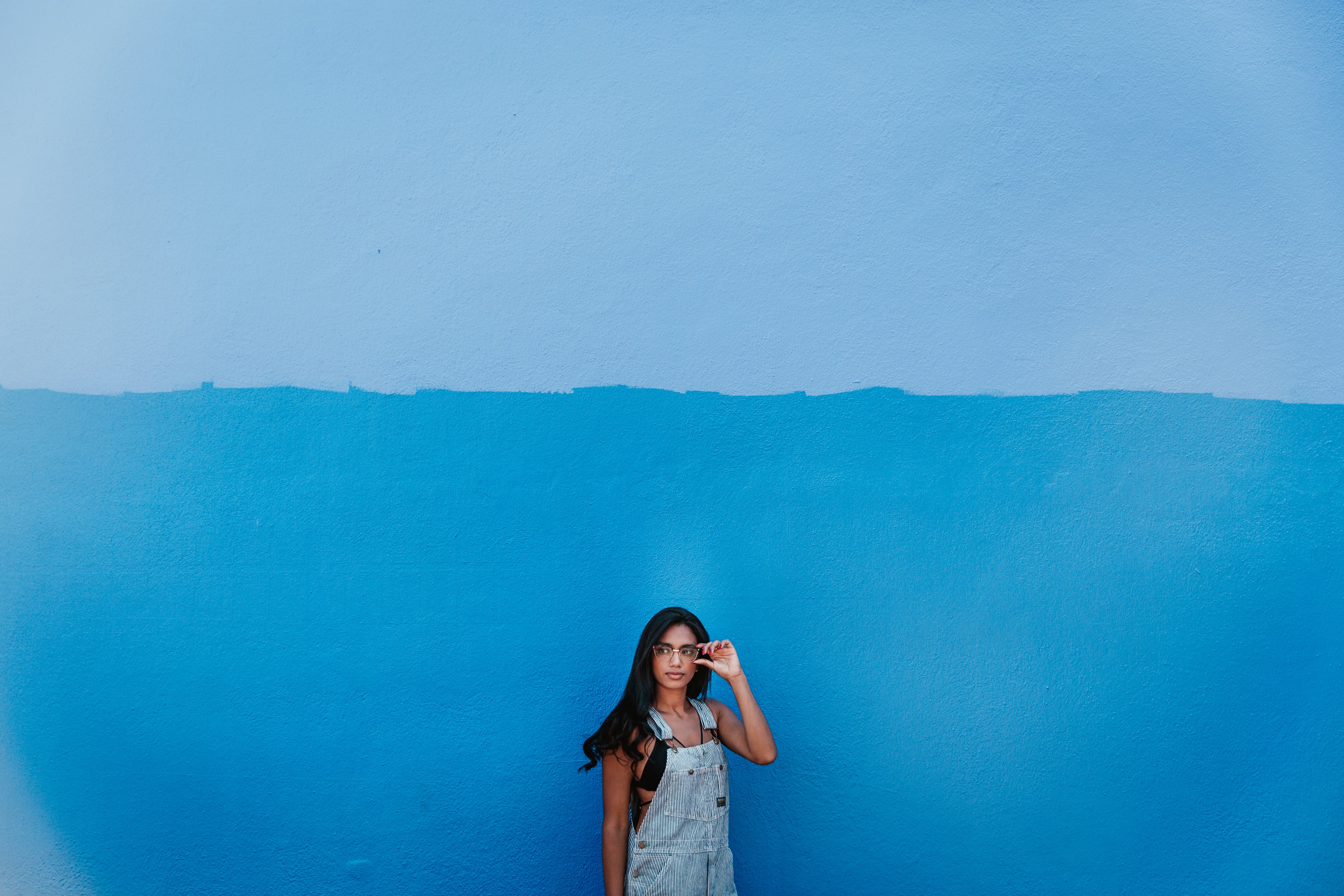 files/woman-in-front-of-blue-wall-adjusts-glasses.jpg